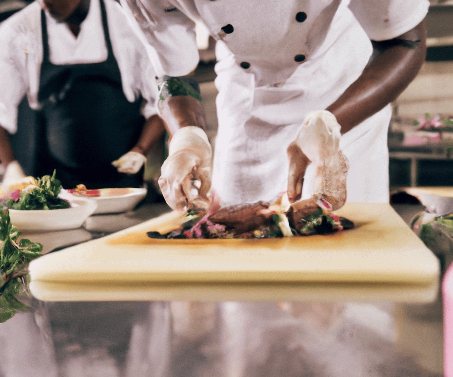 Chef plating a finished meal on a restaurant kitchen counter