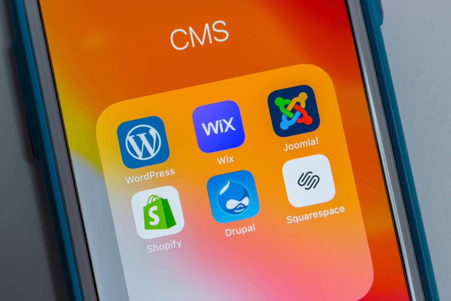 Phone screen with website platform apps such as WordPress and Shopify
