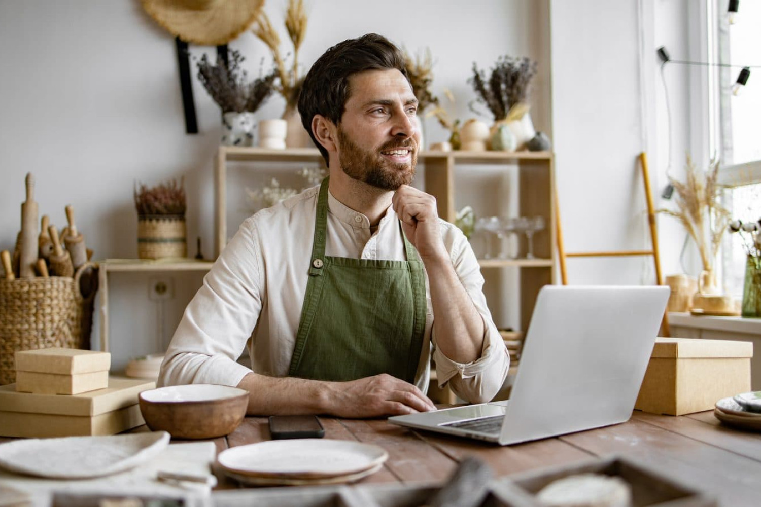 Small business owner working at a laptop in his workshop
