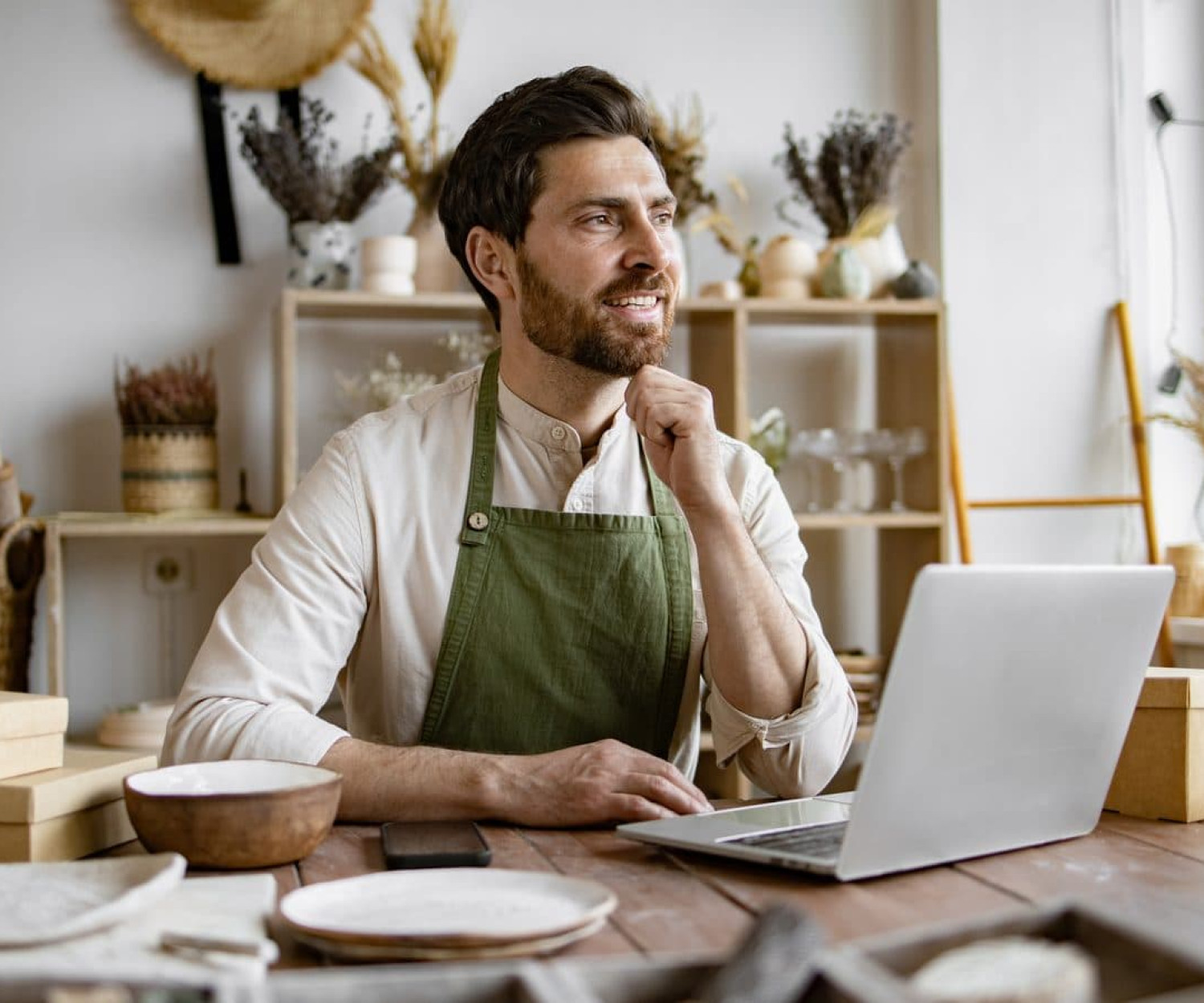 Small business owner working at a laptop in his workshop