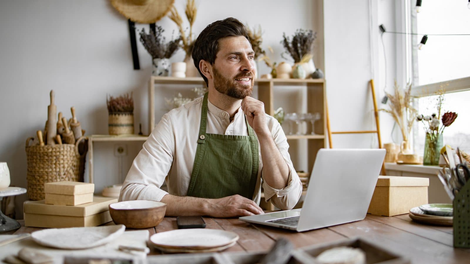 Small business owner working on a laptop in his workshop