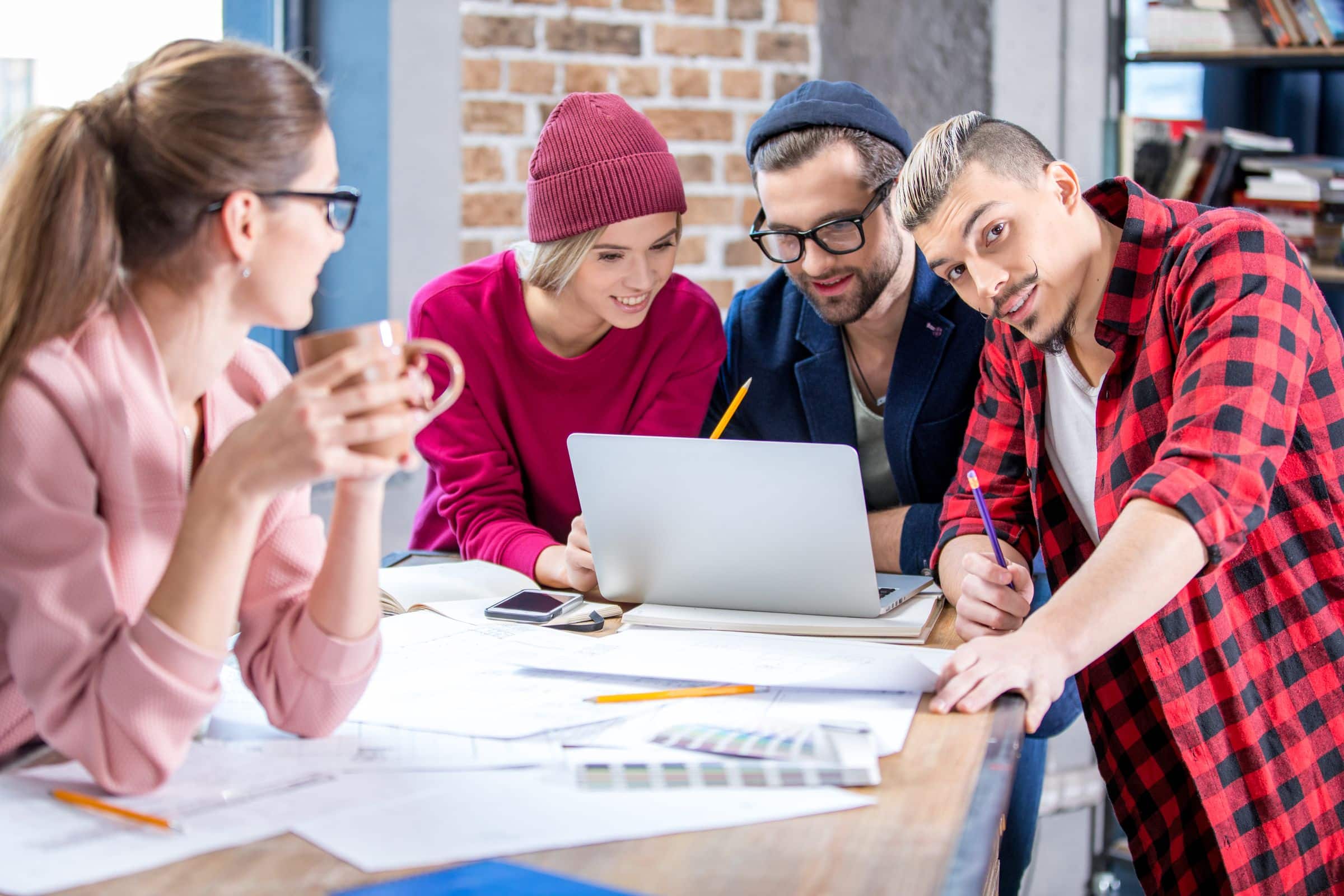 Design team planning a website together around a laptop